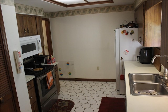 kitchen with light tile patterned flooring, sink, and stainless steel range with electric cooktop