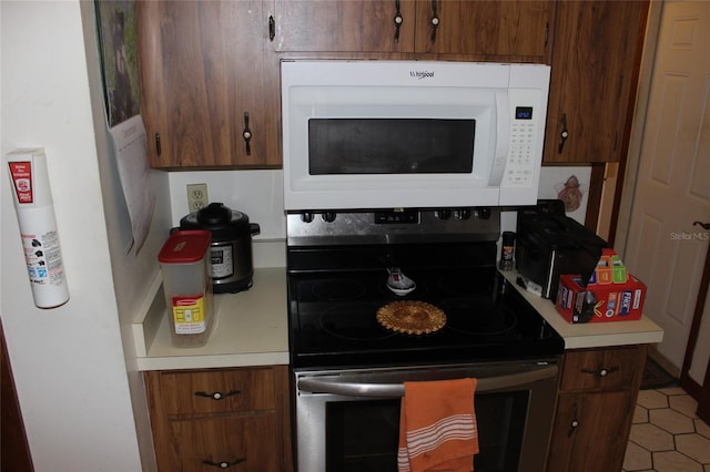 kitchen with tile patterned flooring and electric stove