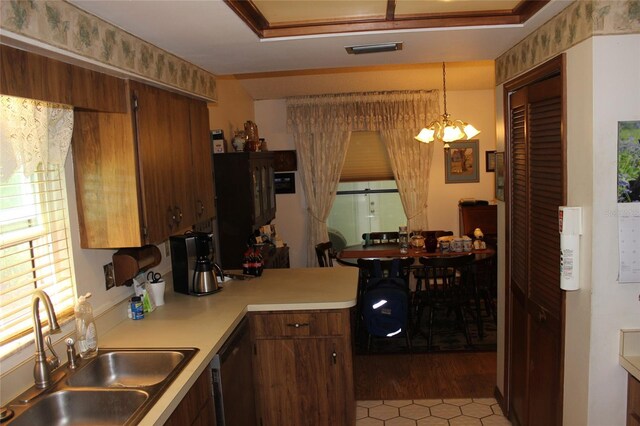 kitchen featuring sink, decorative light fixtures, a chandelier, light hardwood / wood-style floors, and dishwasher