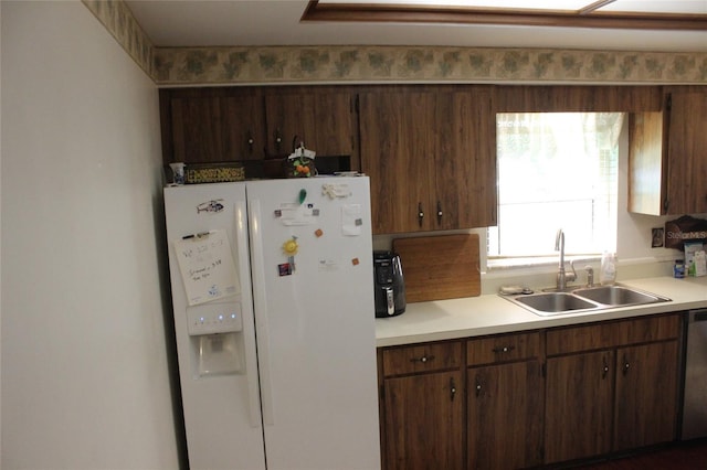 kitchen featuring sink, stainless steel dishwasher, and white refrigerator with ice dispenser