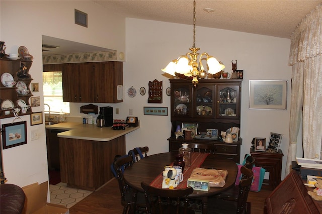 dining space featuring a textured ceiling, a notable chandelier, light tile patterned floors, and sink