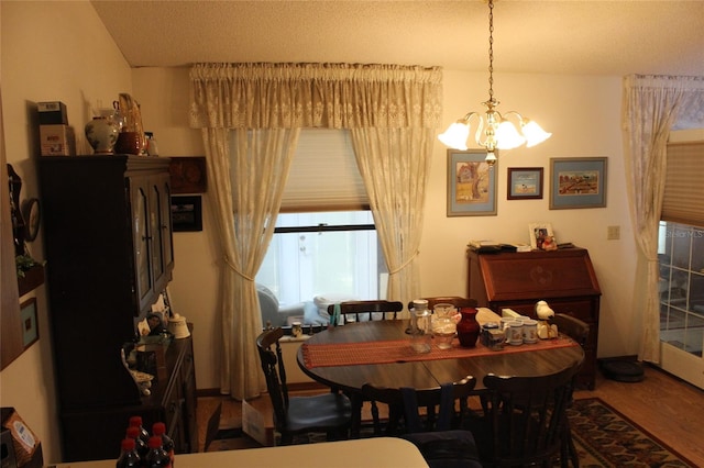 dining space featuring hardwood / wood-style floors and an inviting chandelier