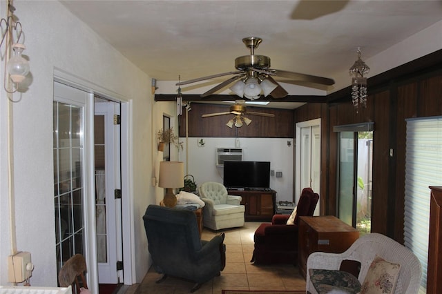 living room with wooden walls, ceiling fan, light tile patterned flooring, and a wall unit AC