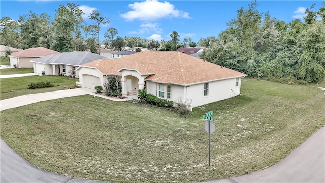 ranch-style house featuring a garage and a front lawn