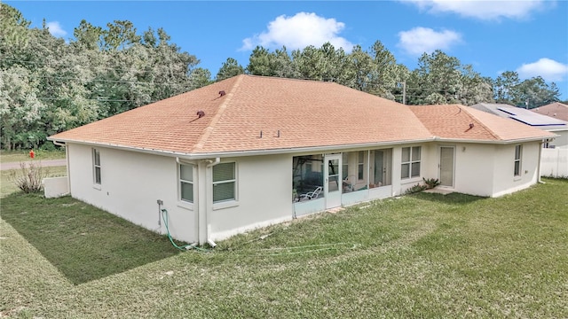 rear view of house with a sunroom and a yard