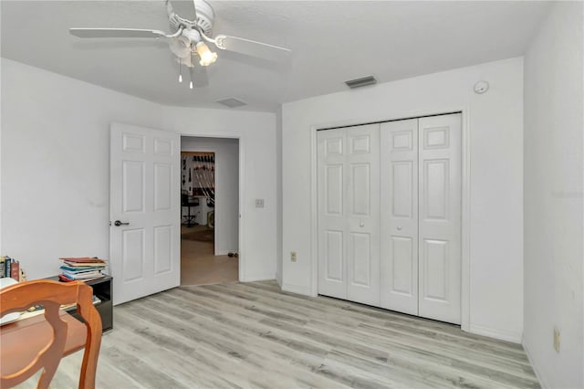 bedroom featuring ceiling fan, a closet, and light hardwood / wood-style flooring