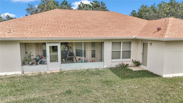 back of house with a lawn and a sunroom