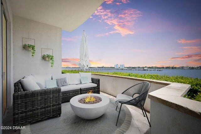 231 Riverside Dr Unit 101-1, Holly Hill, FL 32117 - balcony at dusk with an outdoor living space with a fire pit and a water view