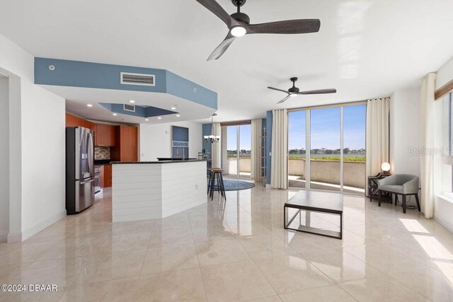 231 Riverside Dr Unit 101-1, Holly Hill, FL 32117 - living area featuring ceiling fan, expansive windows, and baseboards