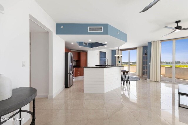 231 Riverside Dr Unit 101-1, Holly Hill, FL 32117 - kitchen with a ceiling fan, dark countertops, freestanding refrigerator, expansive windows, and decorative light fixtures