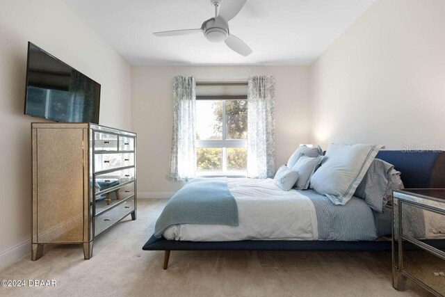 231 Riverside Dr Unit 101-1, Holly Hill, FL 32117 - bedroom featuring baseboards, light colored carpet, and ceiling fan