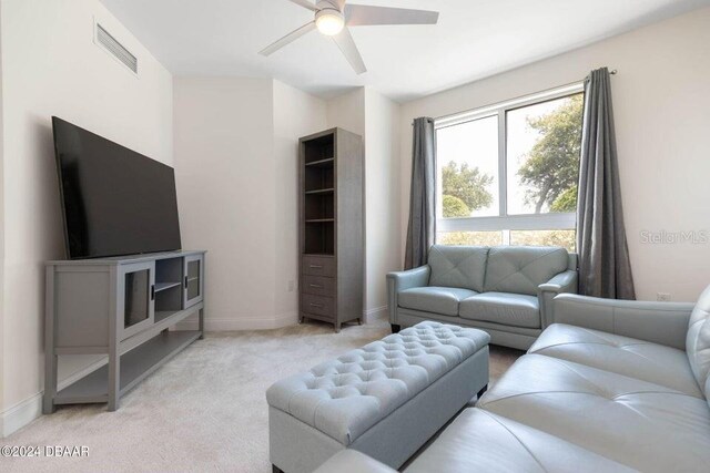 231 Riverside Dr Unit 101-1, Holly Hill, FL 32117 - living area featuring a ceiling fan, light colored carpet, and baseboards
