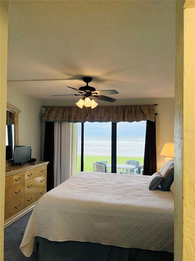 carpeted bedroom featuring a textured ceiling and ceiling fan