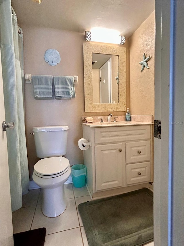 bathroom featuring tile patterned flooring, toilet, and vanity