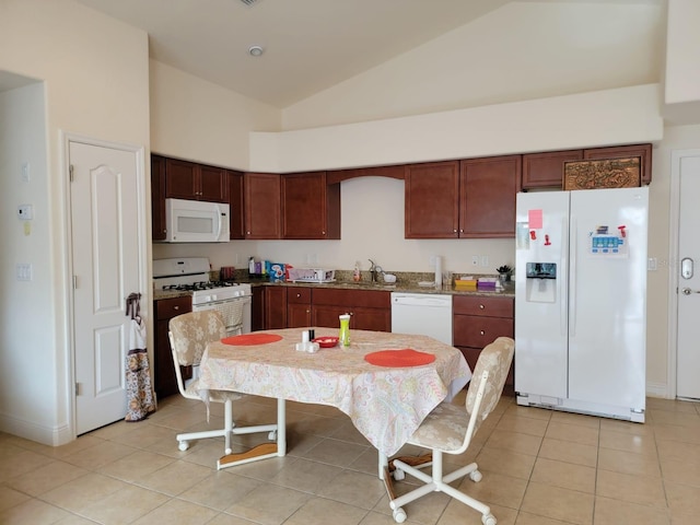 kitchen featuring high vaulted ceiling, light tile patterned flooring, white appliances, a sink, and baseboards