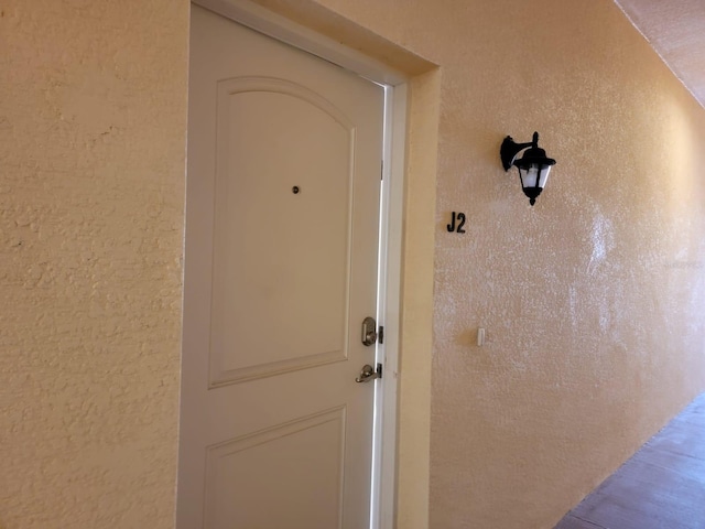 doorway to property featuring stucco siding