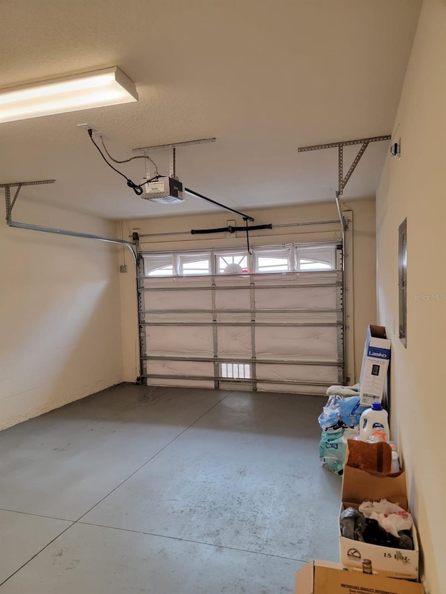 garage with a garage door opener and electric panel