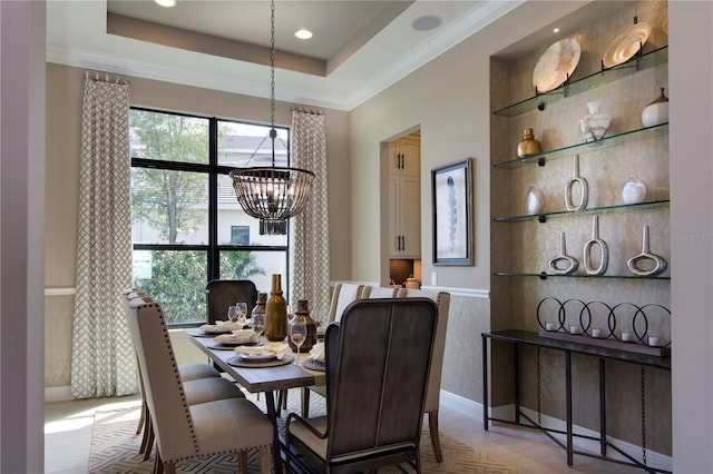 dining room featuring a chandelier, crown molding, and a raised ceiling