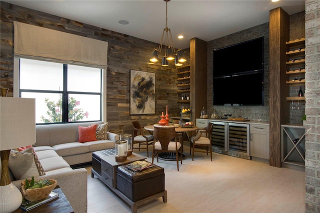 living room with bar area, a notable chandelier, and beverage cooler