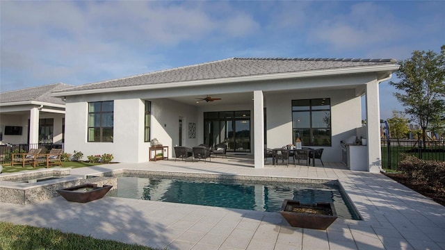 back of house featuring an outdoor fire pit, stucco siding, a patio, fence, and ceiling fan