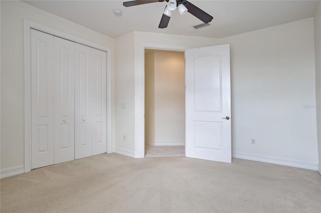 unfurnished bedroom featuring ceiling fan, a closet, and light carpet