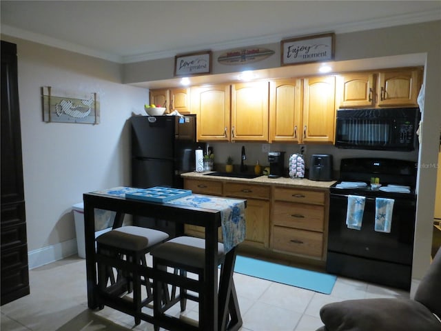 kitchen with baseboards, ornamental molding, light countertops, black appliances, and a sink