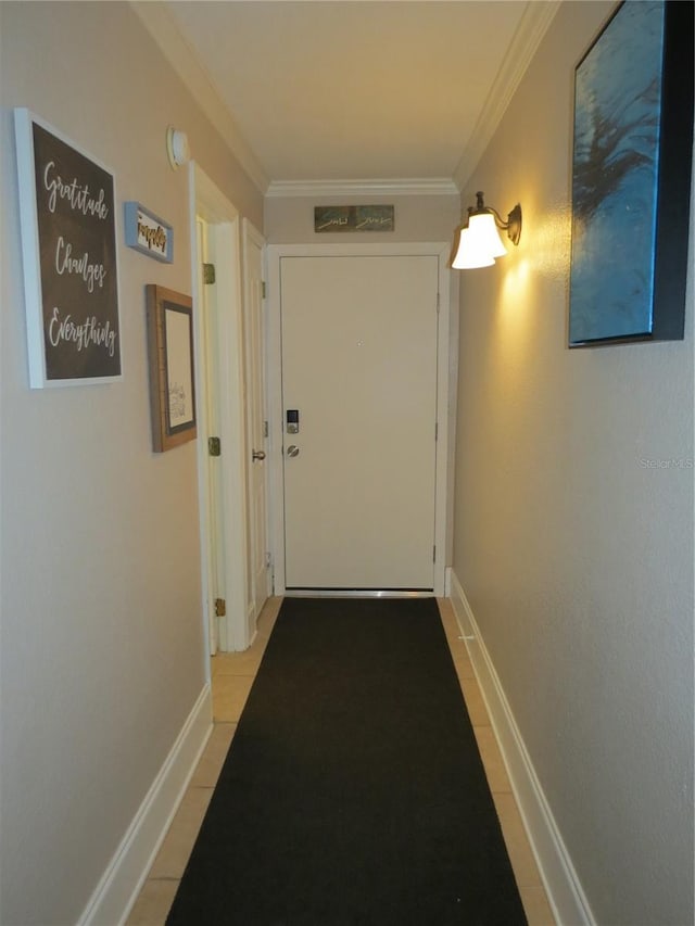 hall featuring baseboards and crown molding