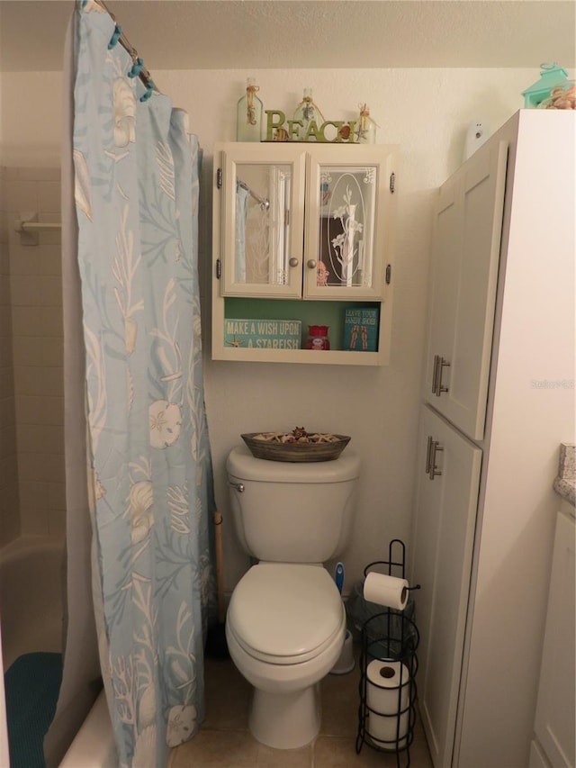 bathroom with shower / bathtub combination with curtain, toilet, and tile patterned floors