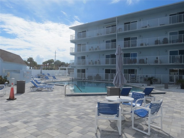 pool with a patio area and fence