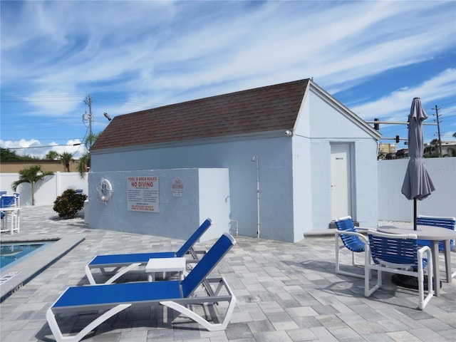 view of outbuilding featuring a fenced backyard, outdoor dining area, and an outdoor structure