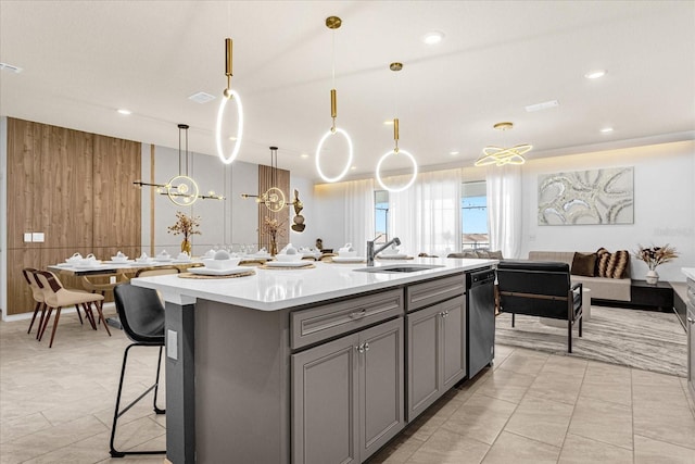 kitchen featuring light tile patterned floors, sink, wooden walls, and an island with sink