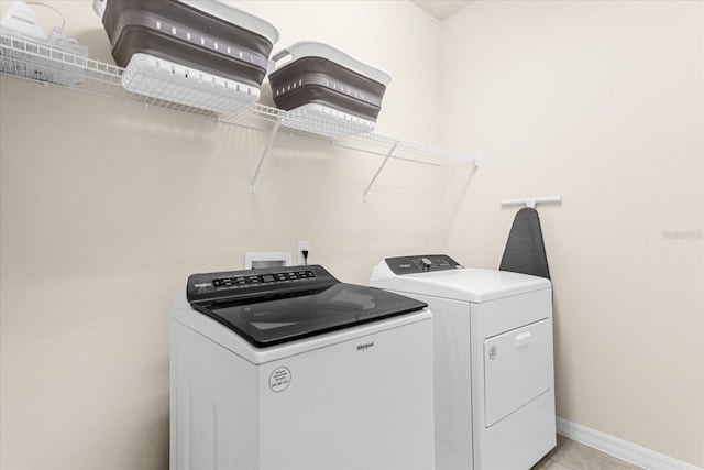 clothes washing area with washer and dryer and light tile patterned floors