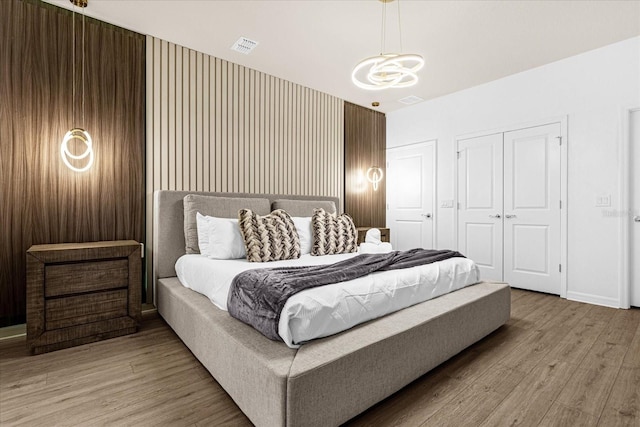 bedroom featuring light wood-type flooring and a chandelier