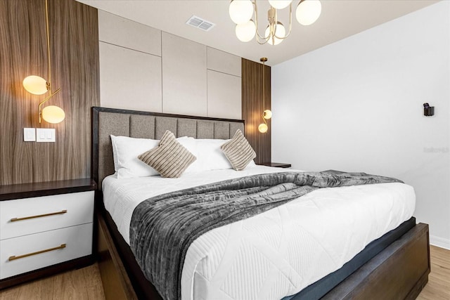 bedroom featuring an inviting chandelier and wood-type flooring