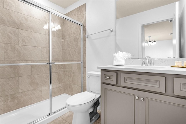 bathroom with a shower with door, toilet, tile patterned flooring, vanity, and a notable chandelier