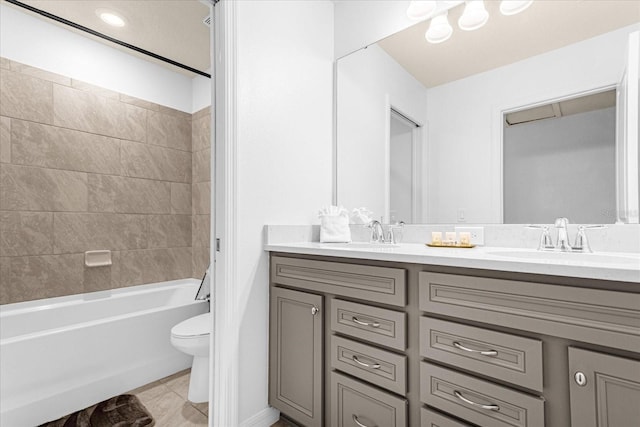 full bathroom with toilet, tiled shower / bath combo, vanity, and tile patterned floors