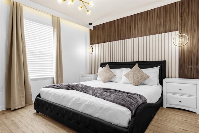 bedroom featuring a notable chandelier and light hardwood / wood-style floors