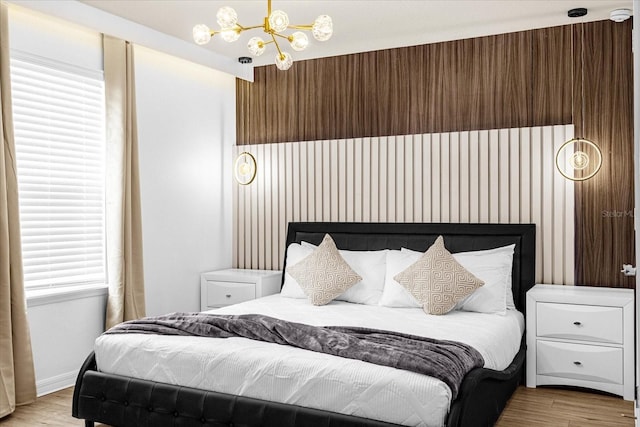 bedroom featuring light wood-type flooring and a chandelier