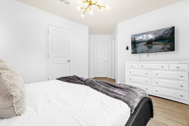 bedroom featuring light hardwood / wood-style floors and an inviting chandelier