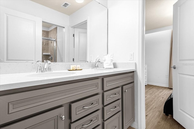 bathroom with wood-type flooring, walk in shower, and vanity