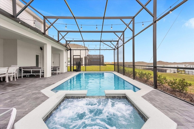 view of swimming pool featuring a lanai, an in ground hot tub, a patio area, and a yard