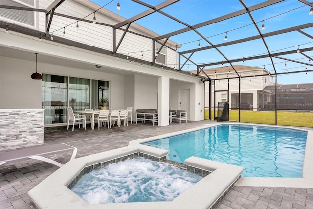 view of pool with an in ground hot tub, glass enclosure, and a patio