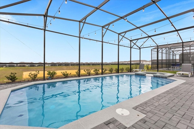 view of swimming pool with an in ground hot tub, glass enclosure, and a patio area