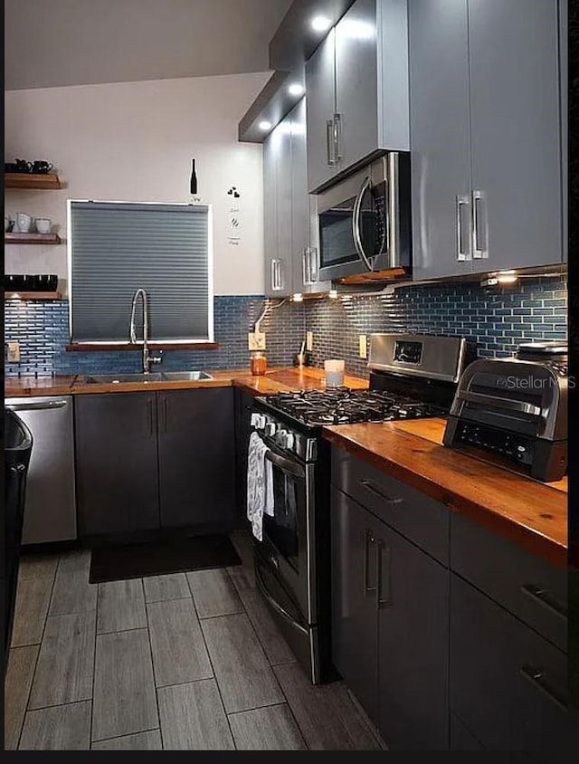 2019 Jaffa Ct, Clermont, FL 34714 - kitchen with stainless steel appliances, wood counters, backsplash, open shelves, and wood tiled floors