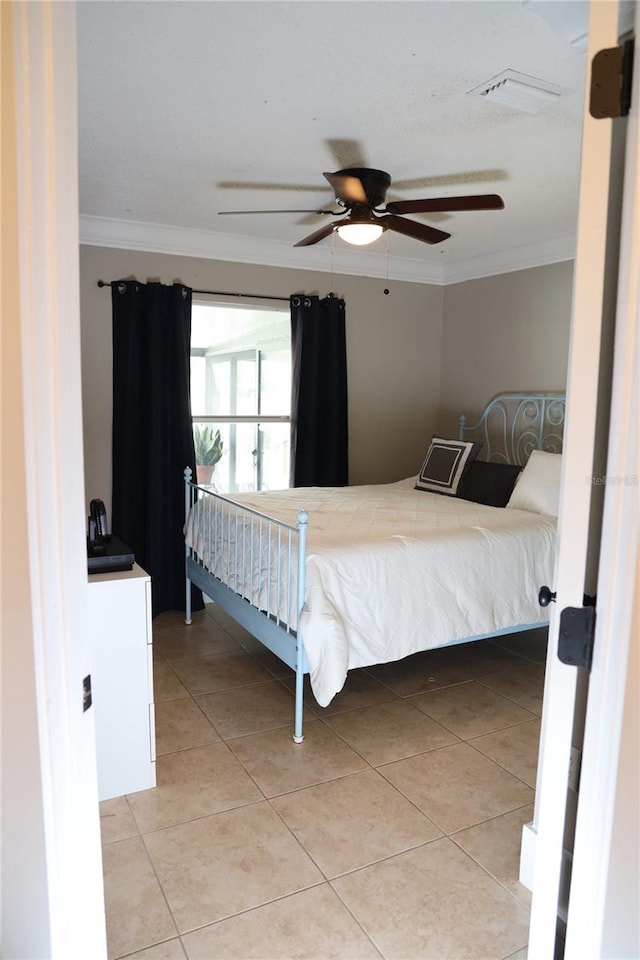 bedroom with ceiling fan, light tile patterned flooring, and ornamental molding