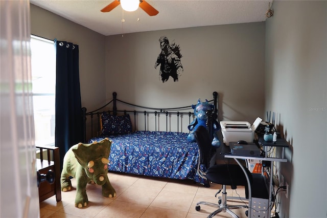 bedroom featuring a textured ceiling, light tile patterned floors, and ceiling fan