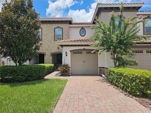 mediterranean / spanish-style house featuring a front yard and a garage