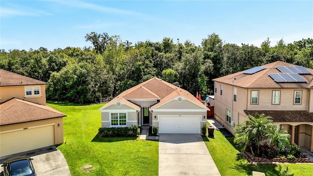 view of front of home with solar panels, a garage, and a front lawn