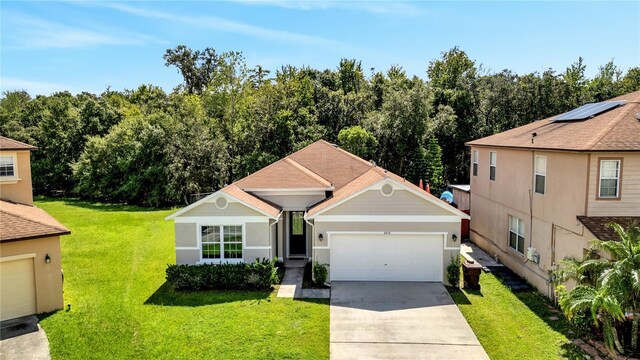 view of front of house featuring a garage and a front lawn