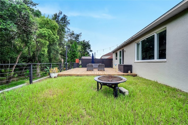 view of yard featuring a wooden deck, central AC unit, and an outdoor fire pit